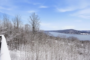 Un paysage enneigé avec un lac et des montagnes en arrière-plan.