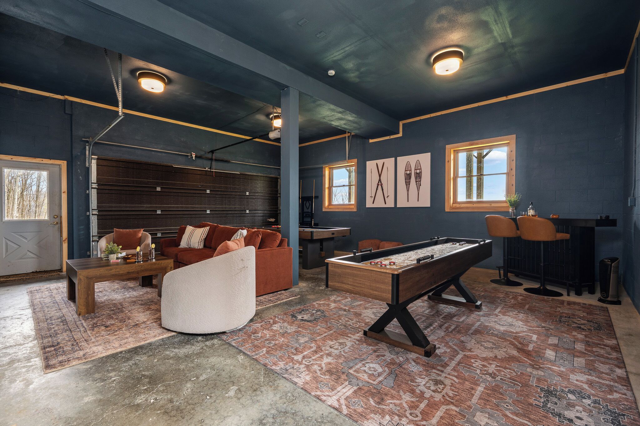 A room with a pool table, a sofa, and a billiards table.