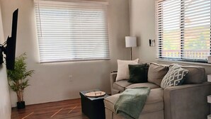 Una sala de estar con un sofá, una lámpara y una mesita.