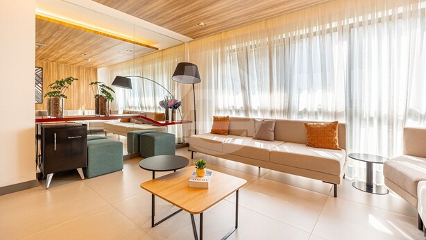 A modern living room with a sofa, a coffee table, a side table, a lamp, and a bookshelf. - Estúdio Premium Vila Olímpia -ap1901 (Sao Paulo)