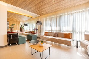 A modern living room with a sofa, a coffee table, a side table, a lamp, and a bookshelf. - Estúdio Premium Vila Olímpia -ap1901 (Sao Paulo)