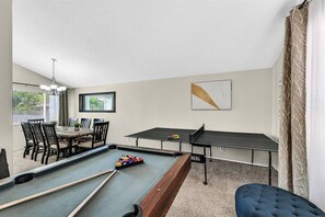 A pool table with billiard balls, a ping pong table, and a dining area with chairs and a table. - Vegas 4BR_Private Pool_BBQ_Games_ Near Strip (Las Vegas)