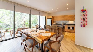 A modern kitchen with wooden cabinets and a large island. - ANANA Yaaxlum 106 S (Tulum)