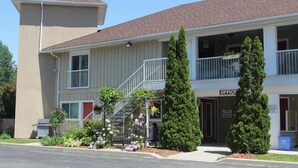 A two-story building with a beige exterior and a red roof. It has a balcony on the second floor and a sign that reads "OFFICE".