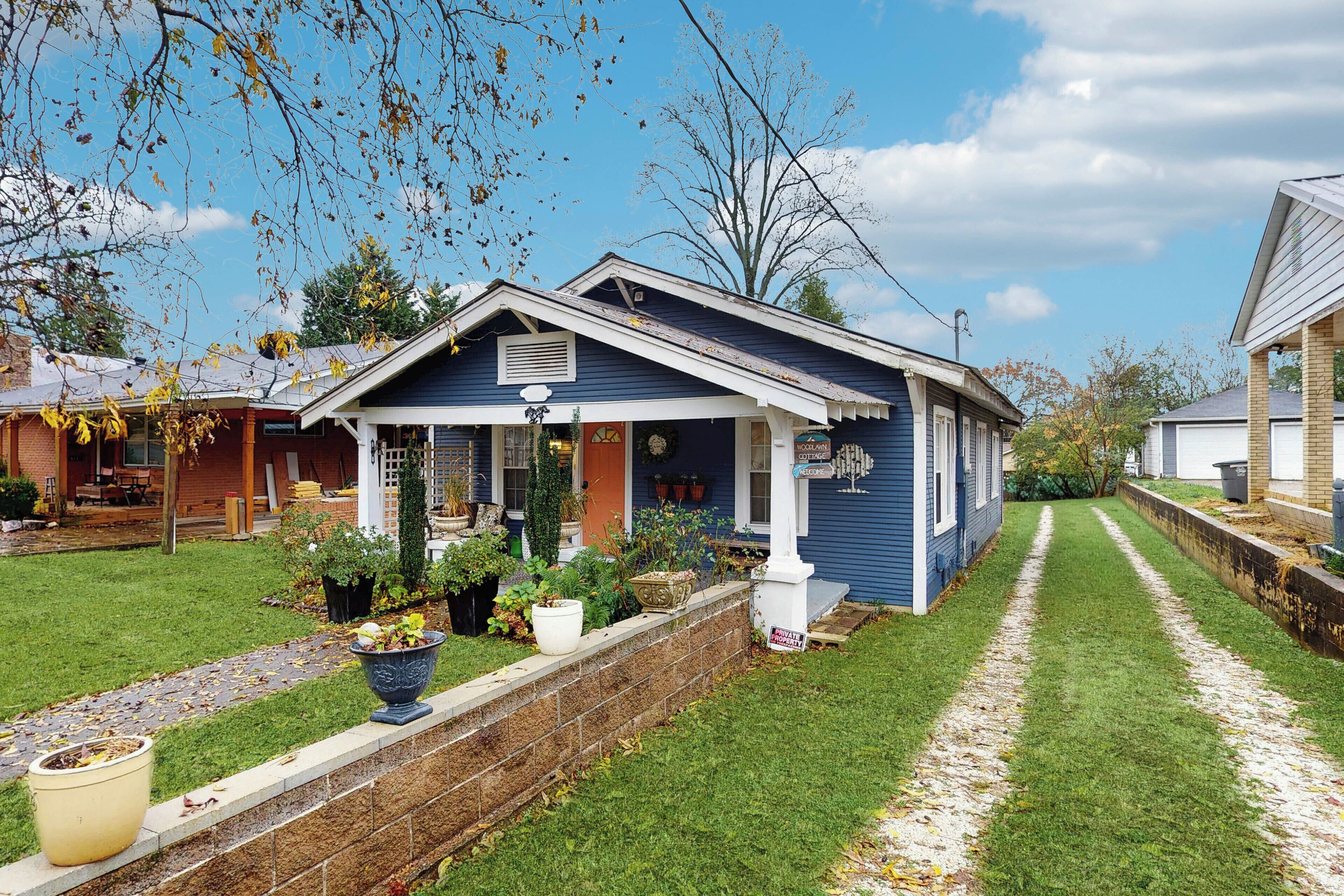 Una casa residenziale con un portico, un muro in mattoni e un vialetto che conduce all'ingresso.