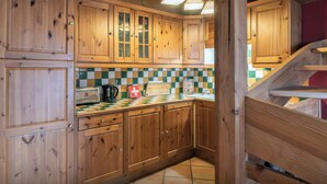 A wooden kitchen with checkered tiles, wooden cabinets, and a staircase. - Chalet Foxly - Well-located, family-friendly chalet - OVO Network (Les Deux Alpes)