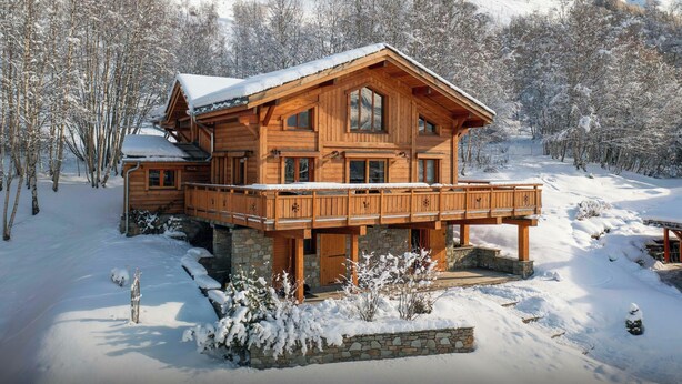 A wooden chalet with a balcony, surrounded by snow-covered trees and mountains. - Chalet Foxly - Well-located, family-friendly chalet - OVO Network (Les Deux Alpes)