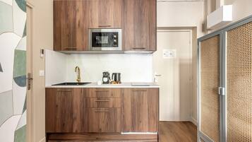 Une cuisine moderne avec des meubles en bois, un four à micro-ondes encastré et une machine à café.