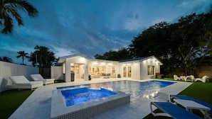 A modern house with a swimming pool, outdoor seating, and a well-lit patio area. - 633 Managed by Brampton Park (Boynton Beach)