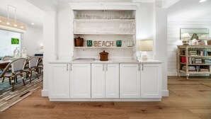 A kitchen with white cabinetry, a central island, and a bookshelf. - 633 Managed by Brampton Park (Boynton Beach)