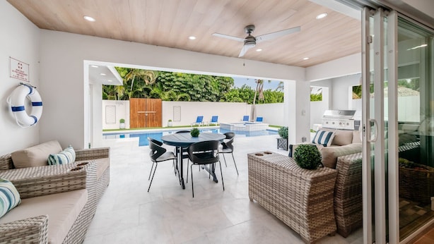 A modern outdoor living area with a pool, seating, and a grill. - 633 Managed by Brampton Park (Boynton Beach)