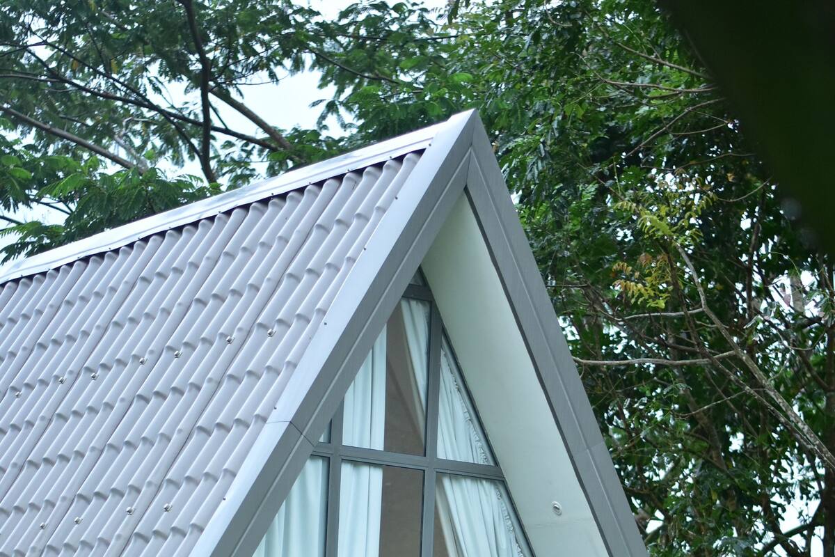 Un bâtiment moderne doté d’un toit triangulaire et de grandes fenêtres.