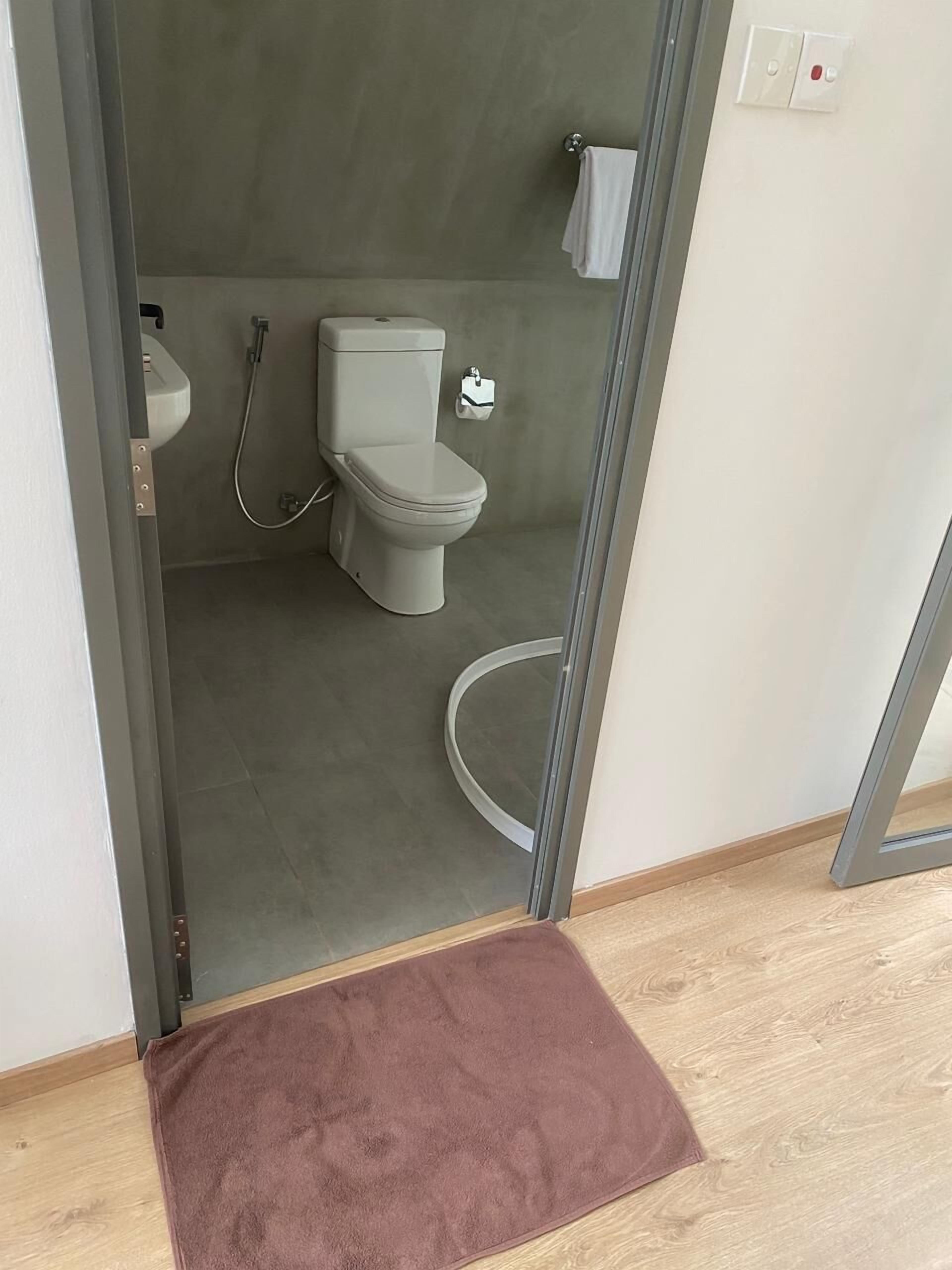 A modern bathroom with a toilet, bidet, and towel rack.