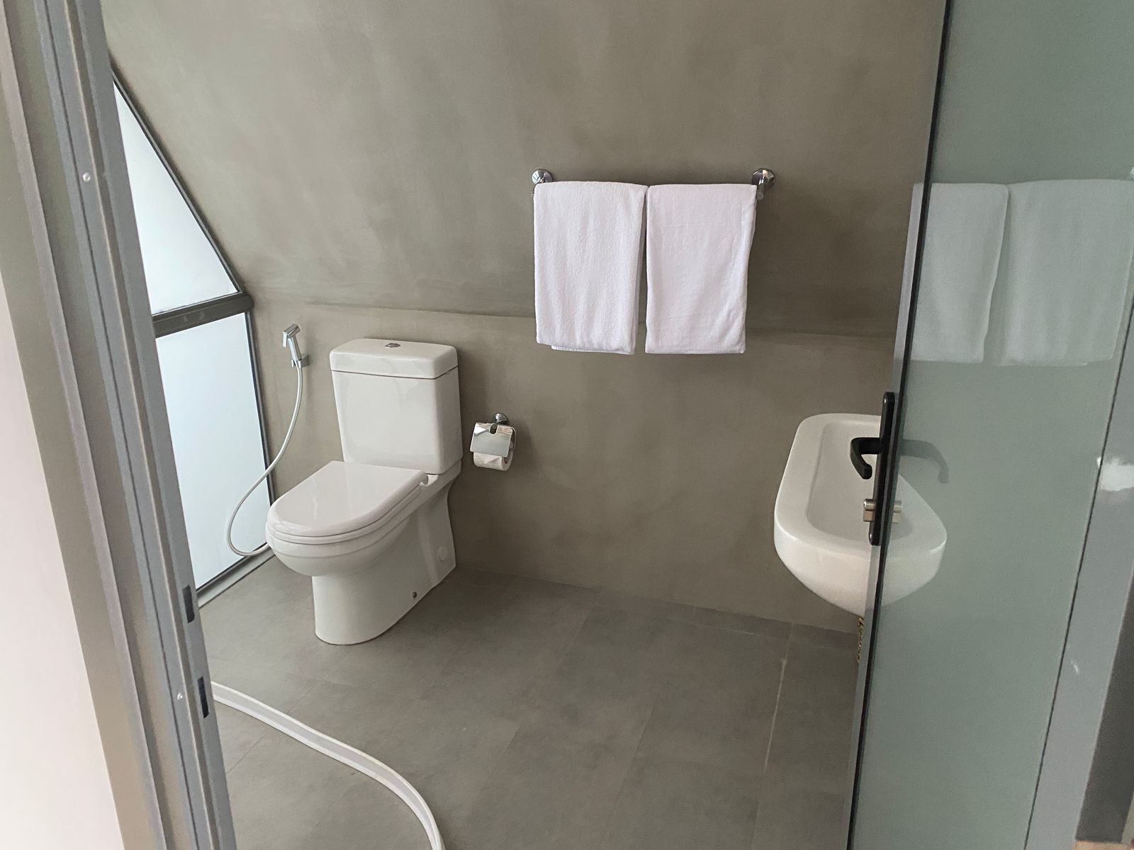 A modern bathroom with a toilet, bidet, and sink.