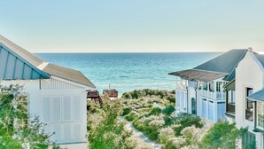 Una proprietà costiera con un vialetto che conduce al mare, caratterizzata da architettura moderna e una vista panoramica sull'oceano.