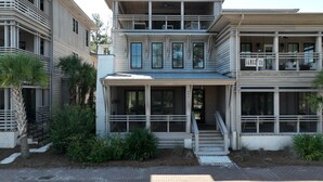 Una casa moderna a due piani con un portico anteriore coperto, ampie finestre e un balcone.