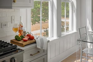 A kitchen with a wooden countertop, a bottle of wine, a glass, tomatoes, and basil. - Screened Porch, Bunk Room & Close to Moreland Amenities (Bluffton)