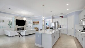 Una cocina moderna con muebles blancos, una isla central y un horno empotrado.