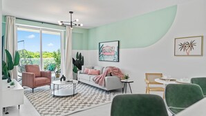 Una sala de estar moderna con un sofá, sillones, una mesa de centro y un comedor con sillas y una mesa.