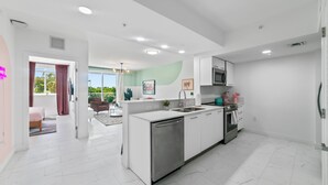 Una cocina moderna con muebles blancos, electrodomésticos de acero inoxidable y una isla central.