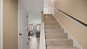 Un escalier avec des marches en bois et des murs blancs.