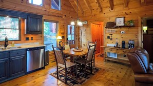 L’intérieur d’un chalet en bois comprend une cuisine, un coin repas et un espace de vie.