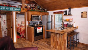 Une cuisine chaleureuse avec des meubles en bois, un îlot central et un réfrigérateur.