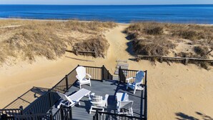 A beachside deck with outdoor seating and a clear view of the ocean. - The Good Stuff - Oceanfront charmer with direct beach access (Virginia Beach)