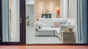 A modern living room with a white sofa, a small side table, and a wooden cabinet. - Hongcheon Yeoyoochae Pension (Hongcheon)