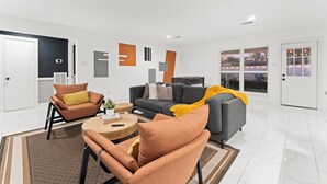 Ein modernes Wohnzimmer mit einer Couch, Sesseln und einem Couchtisch.