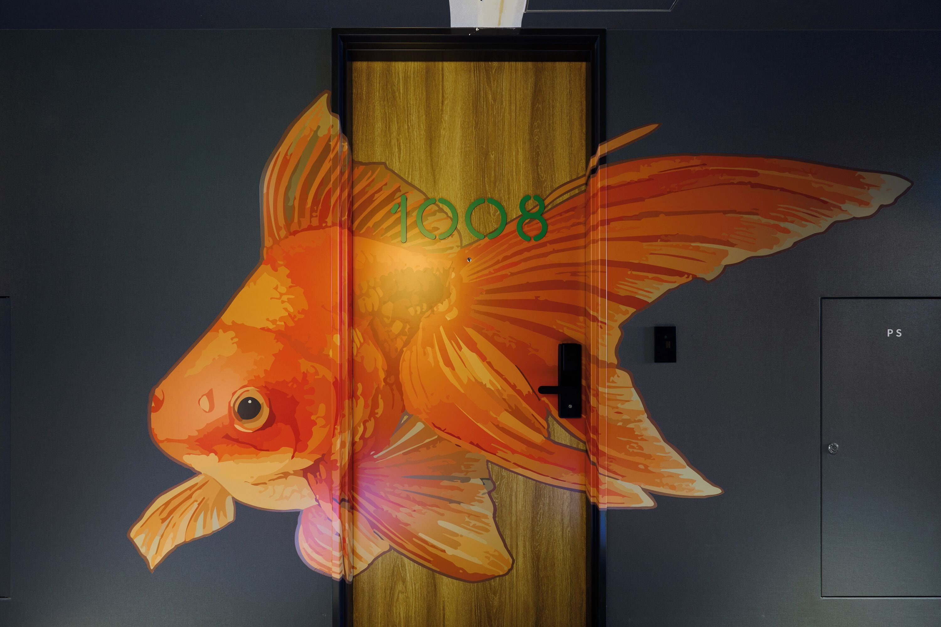 A fish mural on a door with the number '1008' and a door handle.