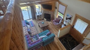 Amplio espacio tipo loft con chimenea de piedra, ventanas grandes y una acogedora zona de estar.