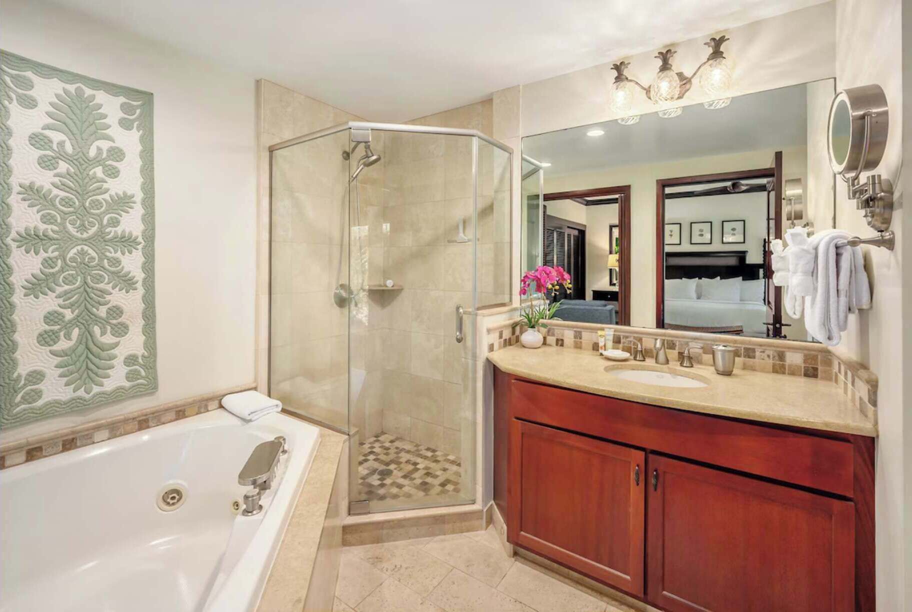 Une salle de bain dotée d’une douche à parois de verre, d’une baignoire sur pieds, d’un meuble-lavabo avec miroir et d’un panneau décoratif mural.