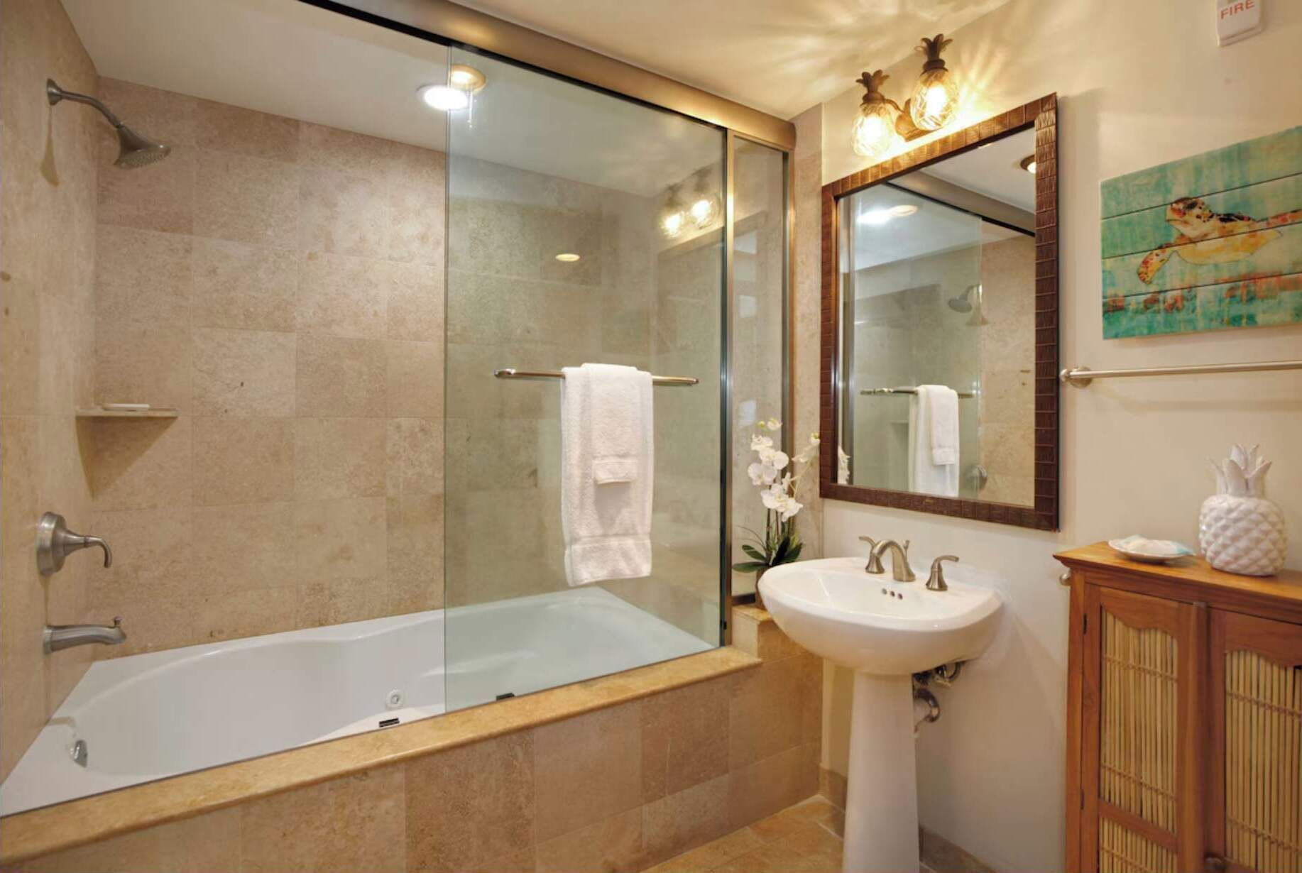 Une salle de bain moderne dotée d’une douche à parois de verre, d’une baignoire sur pieds et d’un lavabo sur colonne.