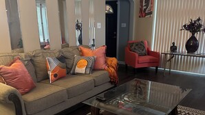 Una sala de estar con un sofá, una mesa de centro y un sillón rojo.