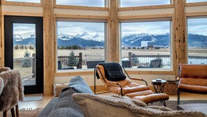 Une pièce confortable avec de grandes fenêtres donnant sur une vue imprenable sur les montagnes.