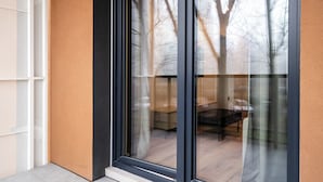 Esterno di un edificio moderno con porta in vetro e schermatura in rete metallica.