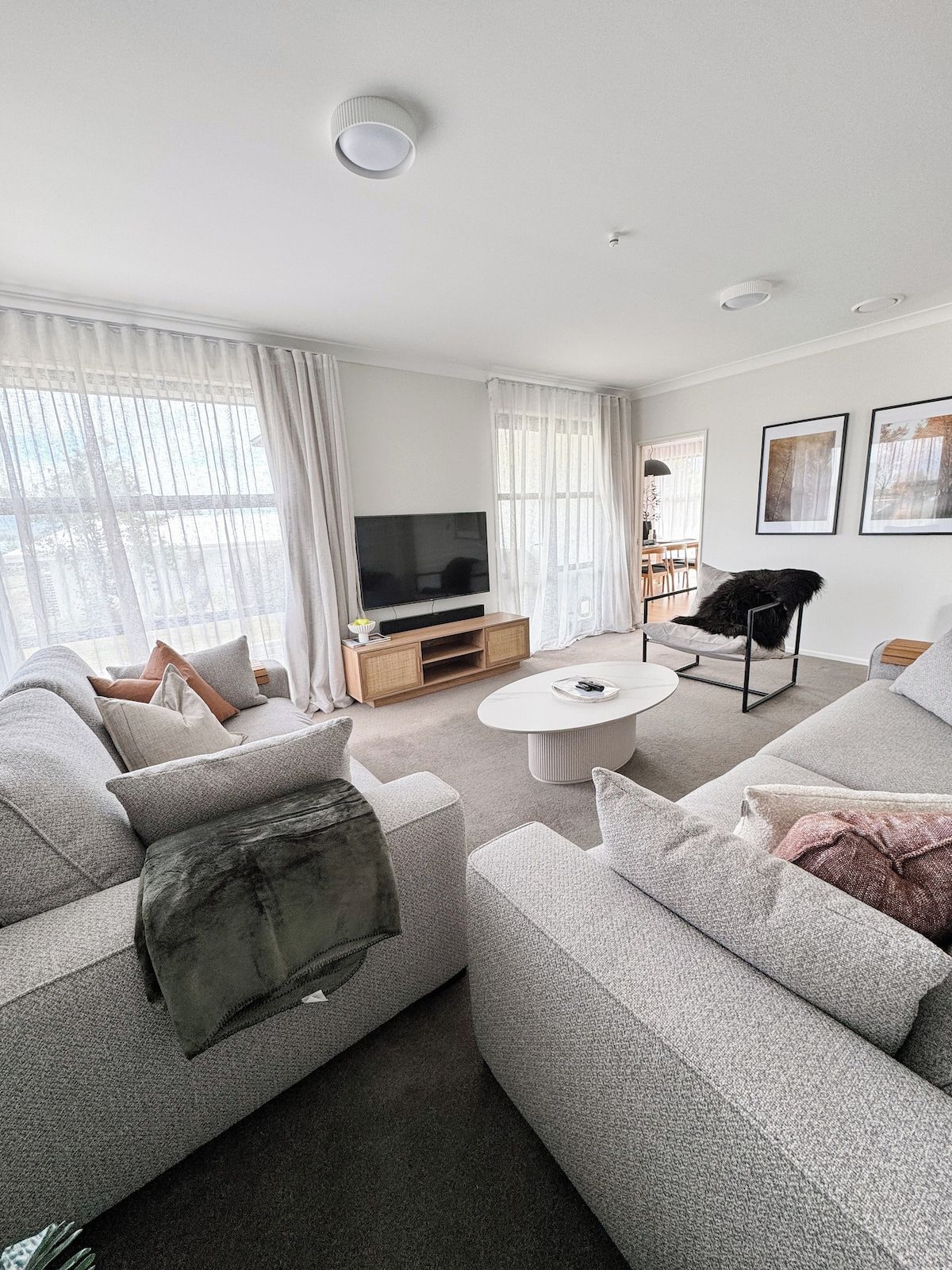 A modern living room with a sofa set, a coffee table, a TV, and a chair.