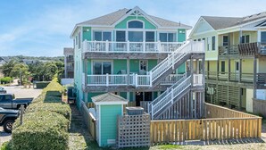 A multi-story building with a balcony and a staircase. - Oceanfront Oasis w/ Elevator, Pool, Hot Tub, Pool Table, Pets OK, Flex Stays (Nags Head)