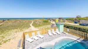 A beachside pool area with lounge chairs and a small pool, overlooking the beach and ocean. - Oceanfront Oasis w/ Elevator, Pool, Hot Tub, Pool Table, Pets OK, Flex Stays (Nags Head)