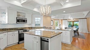 A spacious kitchen with white cabinetry, granite countertops, and stainless steel appliances. - Walks on the Shores • Private Beach Front Access (Indian Shores)