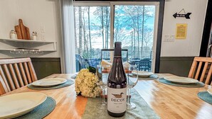 Una mesa de comedor con una botella de Decoy Pinot Noir 2022, platos y copas.