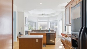 A modern kitchen with wooden cabinets, a black refrigerator, and a built-in dishwasher. - Beautiful Palmetto Dunes home with bikes, pool, hot tub. (Hilton Head Island)