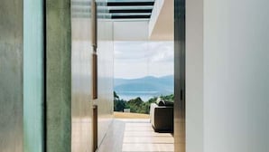 A modern interior with a view of a mountainous landscape through a skylight. - Triptych - The Blunt House (Tasman)