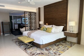 A modern hotel room with a bed, bedside tables, a ceiling fan, and a view of the bathroom.