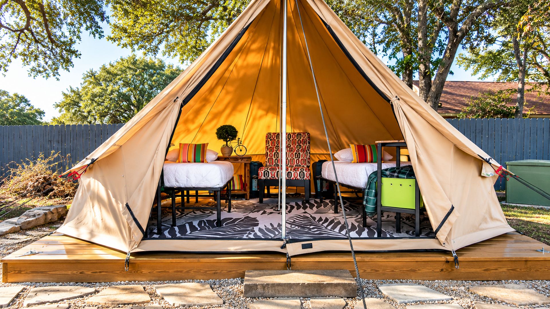 A dome-shaped tent with a bed, two chairs, and a small table.