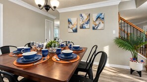 A dining room with a wooden table set for six, surrounded by black chairs. - Glampstead Retreat | BMT|SixFlags|SeaWorld|Cantera (San Antonio)