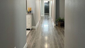 A hallway with a wooden floor, white walls, and a ceiling with recessed lighting. - Peaceful 4-bedroom house near lake access with room for multiple boats. (Moses Lake)