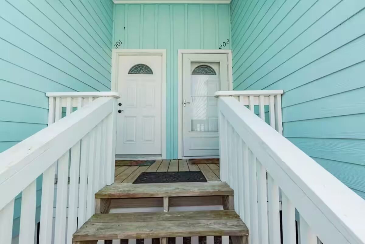 A wooden staircase leading to a door with a window.