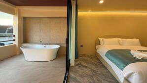 Une chambre d’hôtel moderne, dotée d’une grande baignoire, d’un lit parfaitement fait et offrant une vue sur le paysage urbain par la fenêtre.